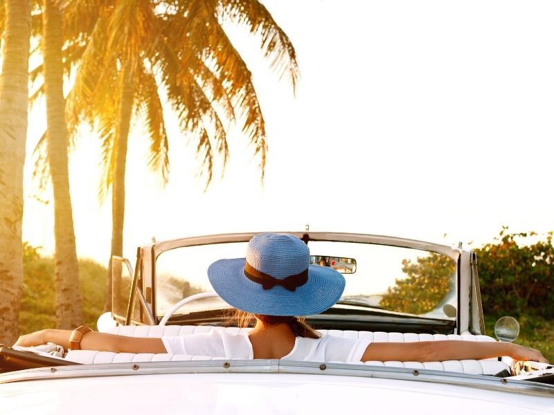 woman wearing a hat riding a car