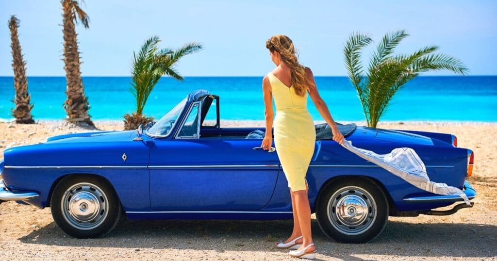 woman in yellow dress opening a blue car