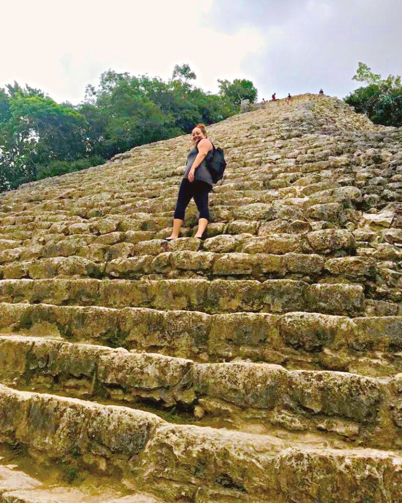 woman climbing Nohoch Mul Pyramid (AKA Ixmoja Pyramid) at the ancient Mayan city of Coba