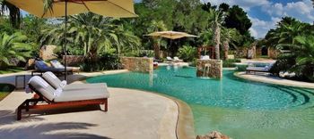 outdoor pool with sun lounges and yellow umbrella in Hacienda Chablé Yucatán